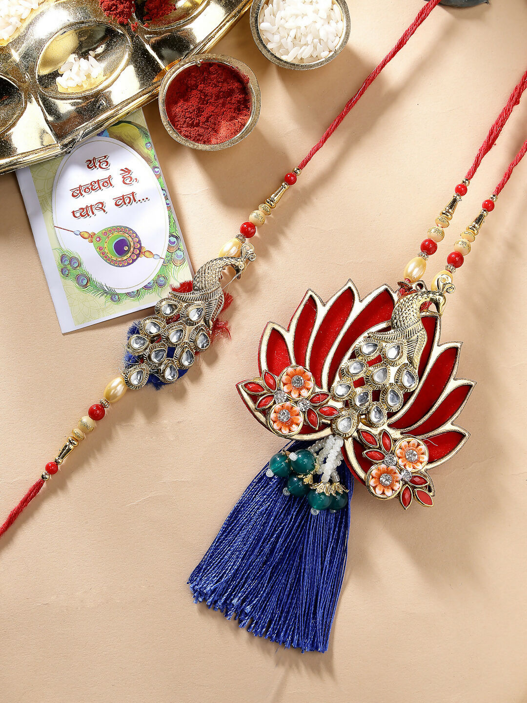 NVR Women & Men Set of 2 Gold-Toned Peacock Design Stone-Studded Bhaiya Bhabhi Rakhi With Roli Chawal & Chocolate | Grocsy