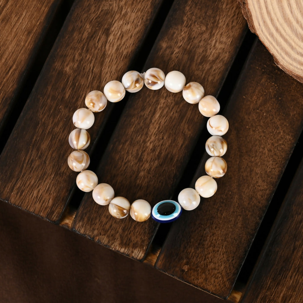 NVR Women & Men Cream-colored Evil Eye Elasticated Rakhi With Roli Chawal | Grocsy