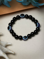 NVR Women & Men Black Evil Eye Elasticated Rakhi With Roli Chawal | Grocsy