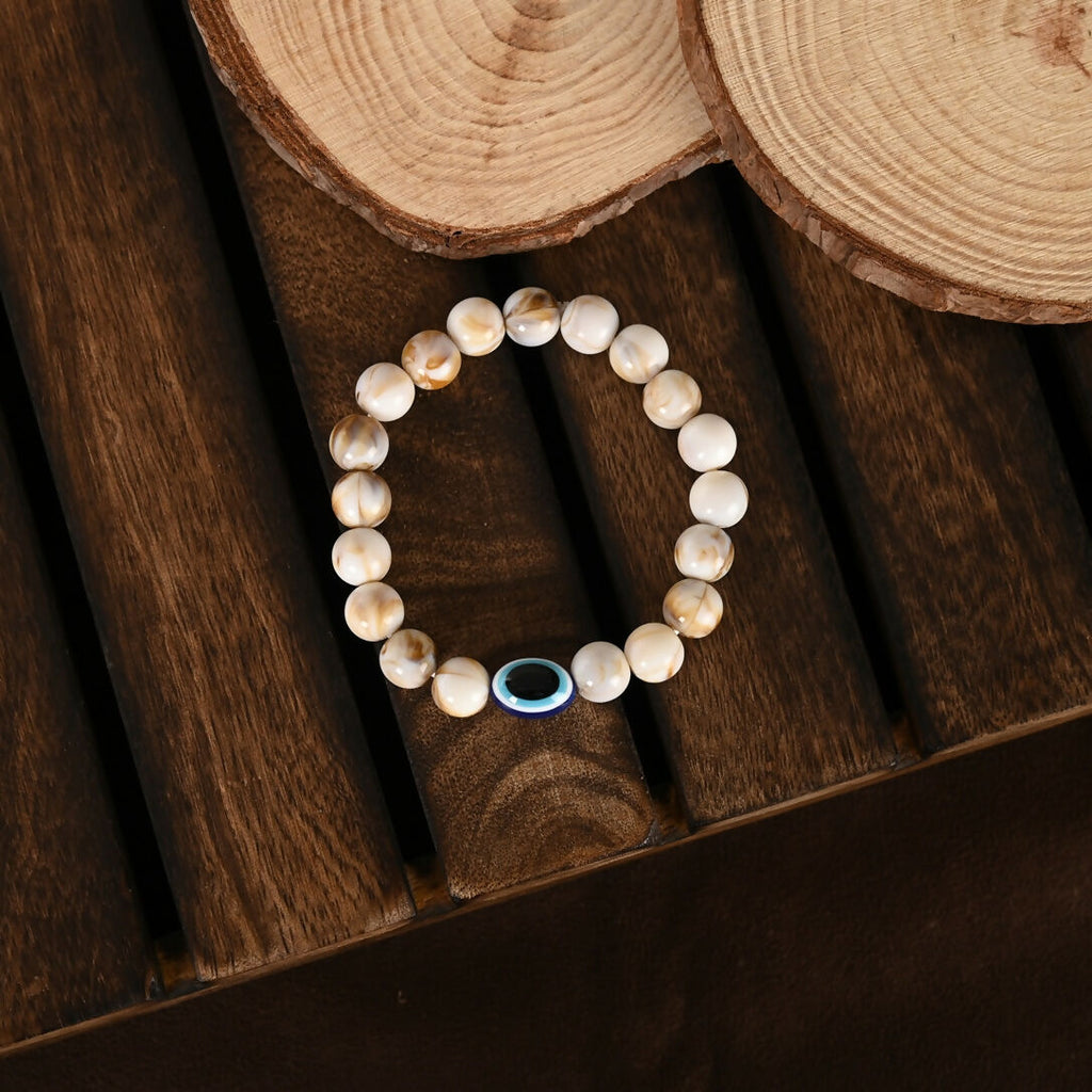 NVR Women & Men Cream-colored Evil Eye Elasticated Rakhi With Roli Chawal | Grocsy