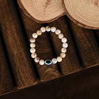 NVR Women & Men Cream-colored Evil Eye Elasticated Rakhi With Roli Chawal | Grocsy