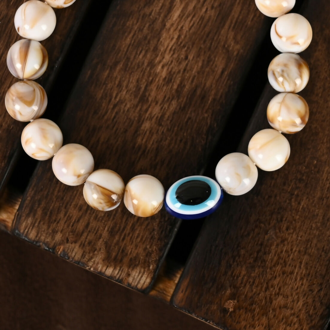 NVR Women & Men Cream-colored Evil Eye Elasticated Rakhi With Roli Chawal | Grocsy