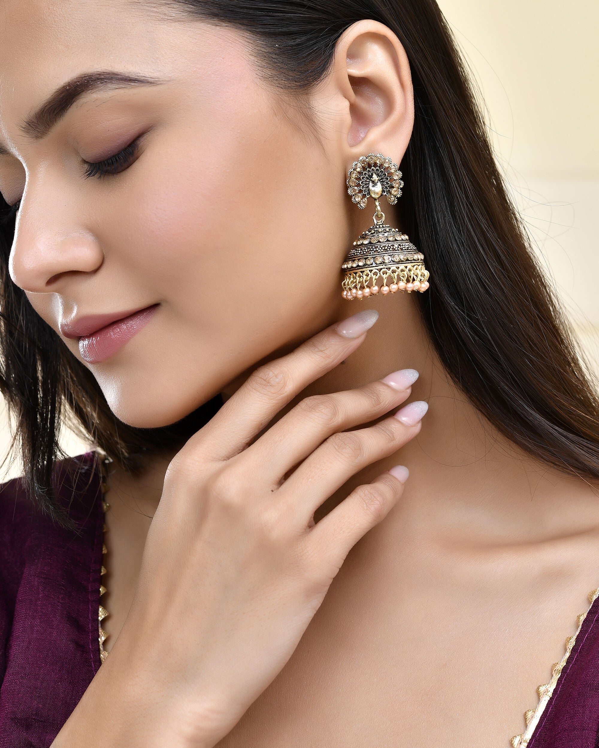 Jewels Nest Antique Gold-Polished Jhumka Earrings with Floral Detailing and Stone Embellishments
