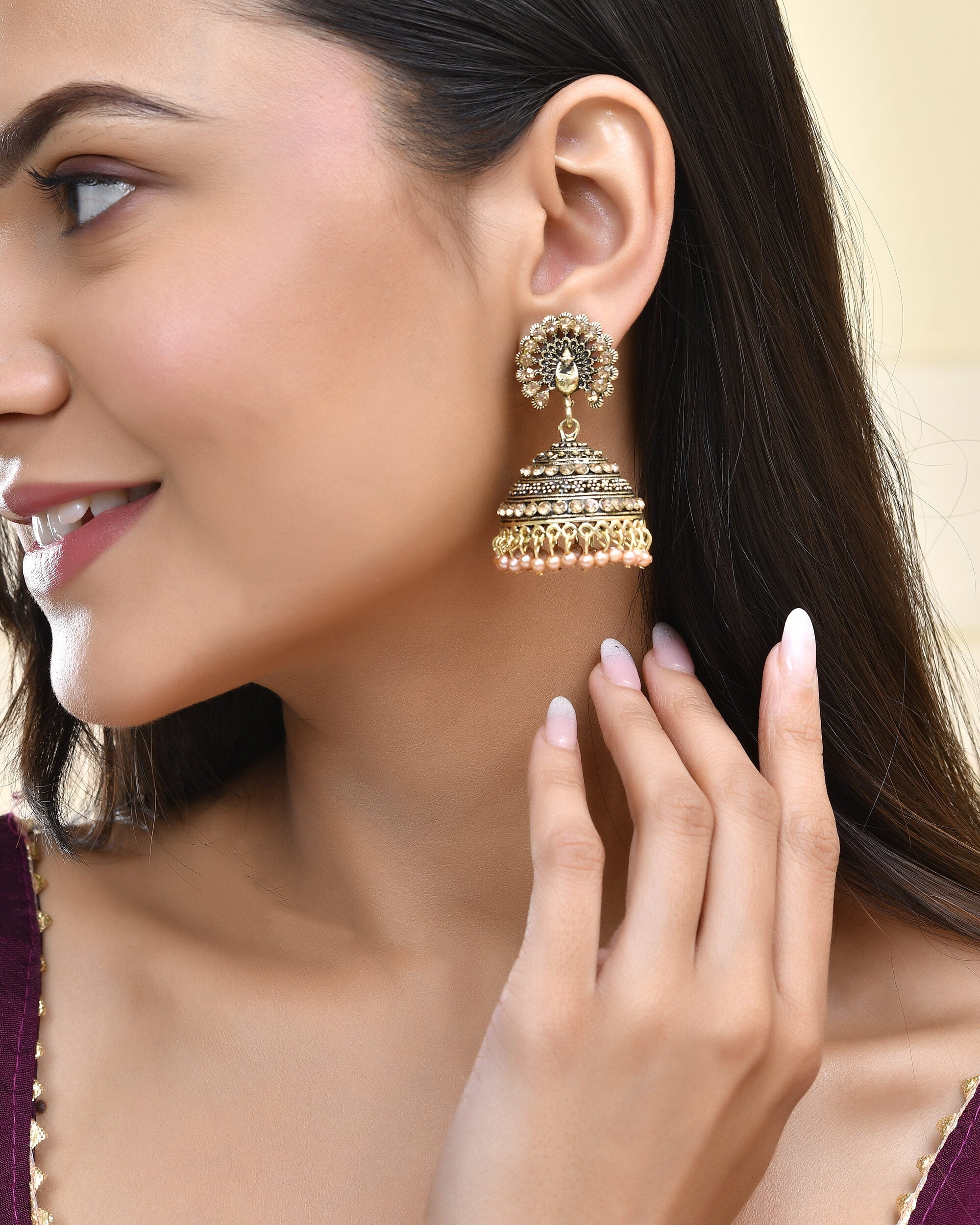 Jewels Nest Antique Gold-Polished Jhumka Earrings with Floral Detailing and Stone Embellishments