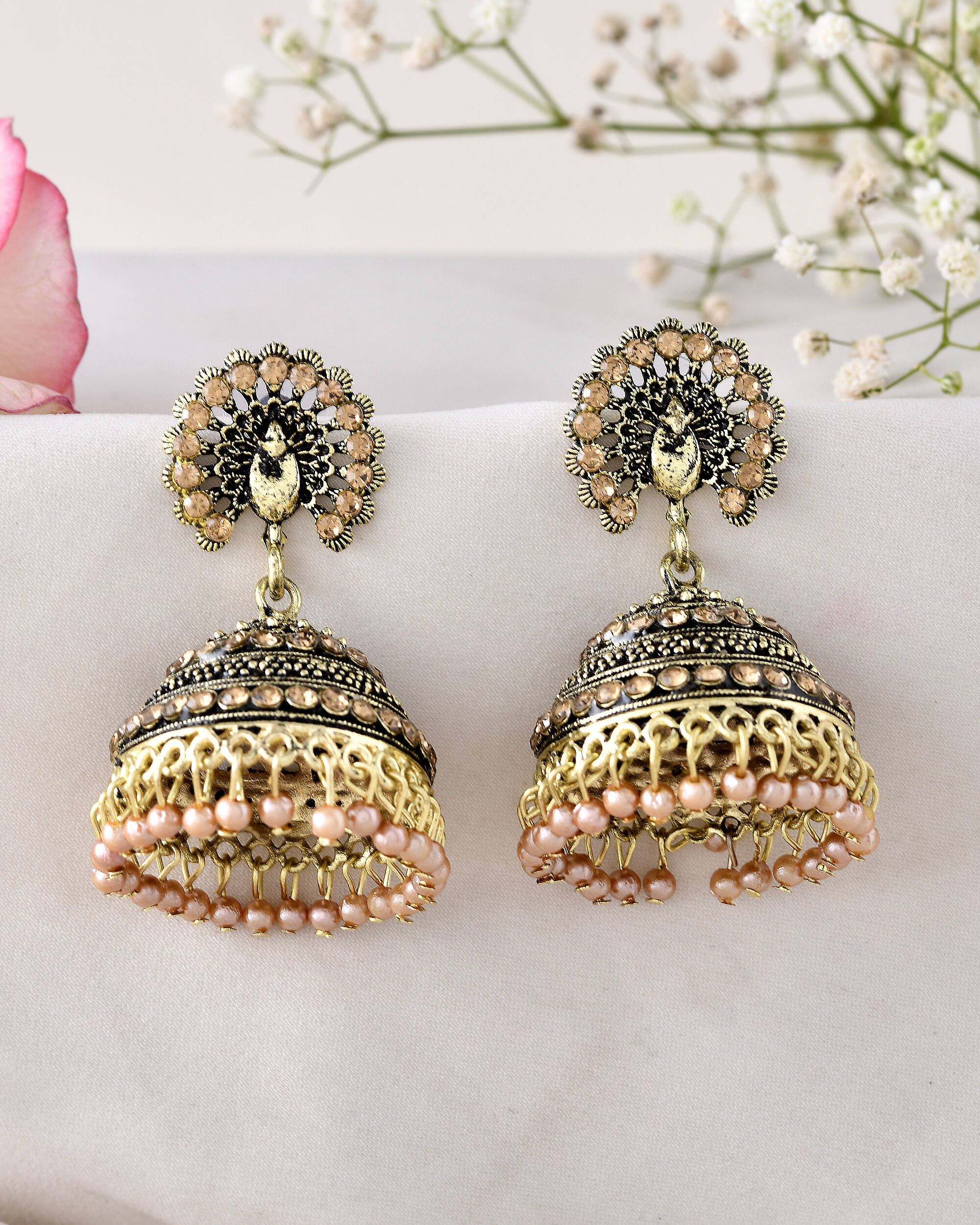 Jewels Nest Antique Gold-Polished Jhumka Earrings with Floral Detailing and Stone Embellishments