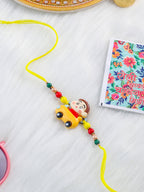 NVR Kids Yellow Cartoon Artificial Beads Rakhi with Roli Chawal Chandan & Mishri | Grocsy