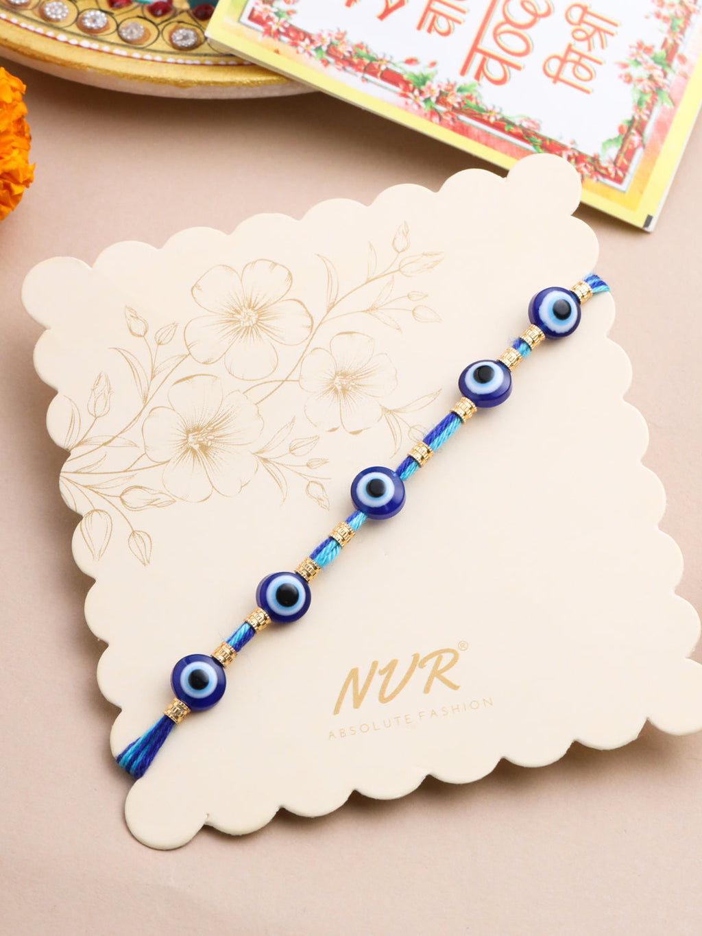 NVR Men's Blue Evil Eye Thread Rakhi with Roli Chawal Chandan & Mishri | Grocsy