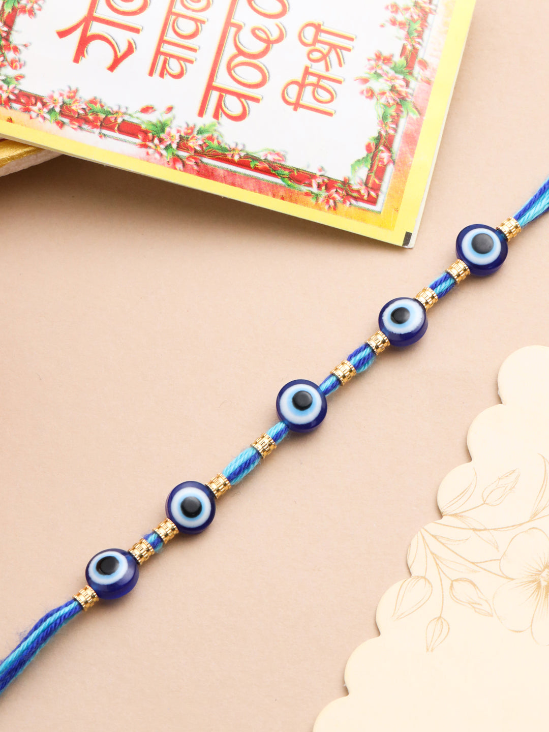 NVR Men's Blue Evil Eye Thread Rakhi with Roli Chawal Chandan & Mishri | Grocsy