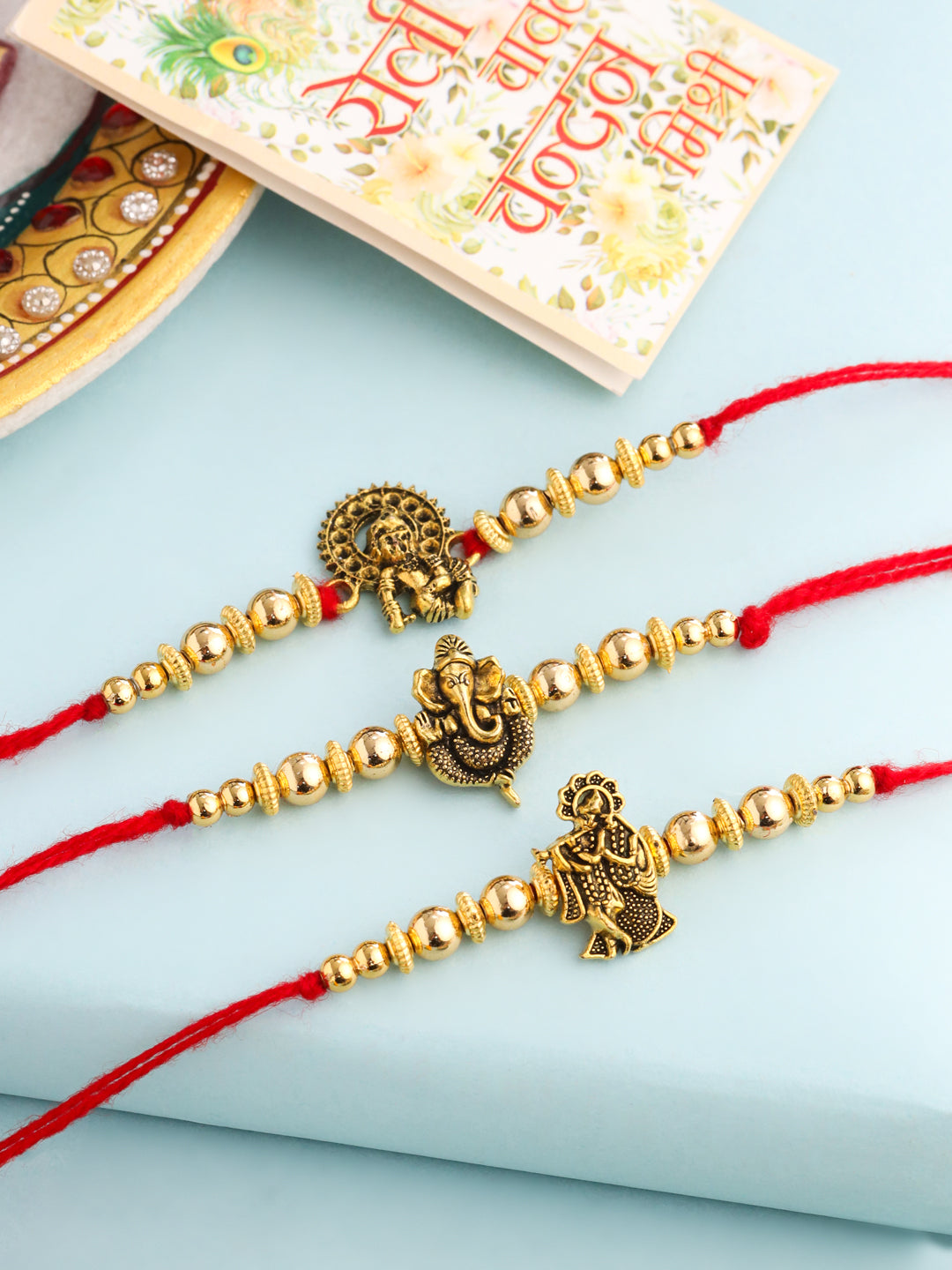 NVR Men Set of 3 Gold Toned Designer Ganesh Ji Thread Rakhi with Roli Chawal Chandan & Mishri | Grocsy