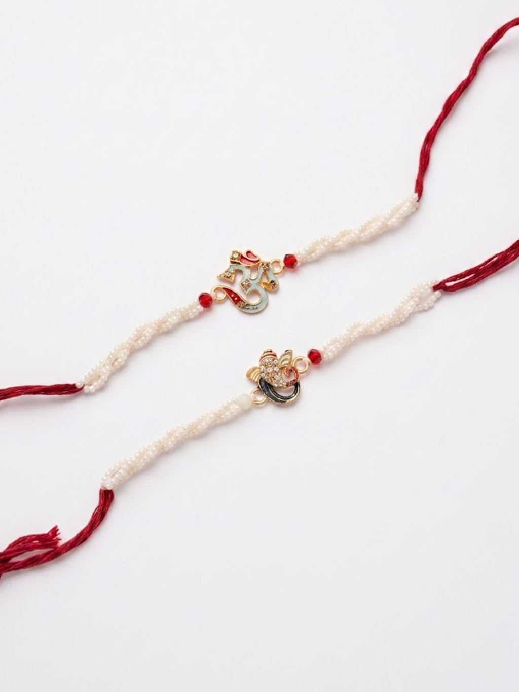 NVR Set of 2 White Pearls Om & Ganesh Ji Thread Rakhi with Roli Chawal Chandan Mishri | Grocsy