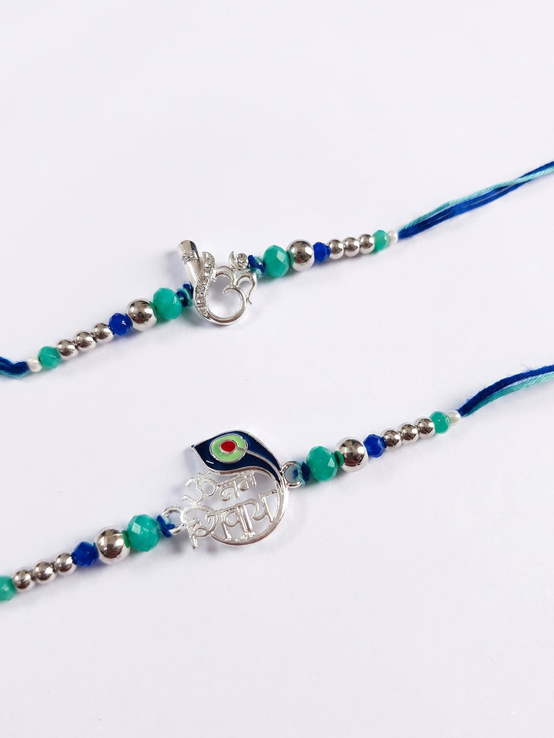 NVR Set of 2 Silver Toned Beaded Religious Thread Rakhi with Roli Chawal Chandan Mishri | Grocsy