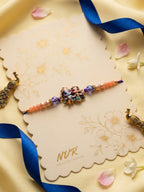 NVR Radha Krishna Multicolor Artificial Beads Thread Rakhi With Roli Chawal Chandan Mishri | Grocsy