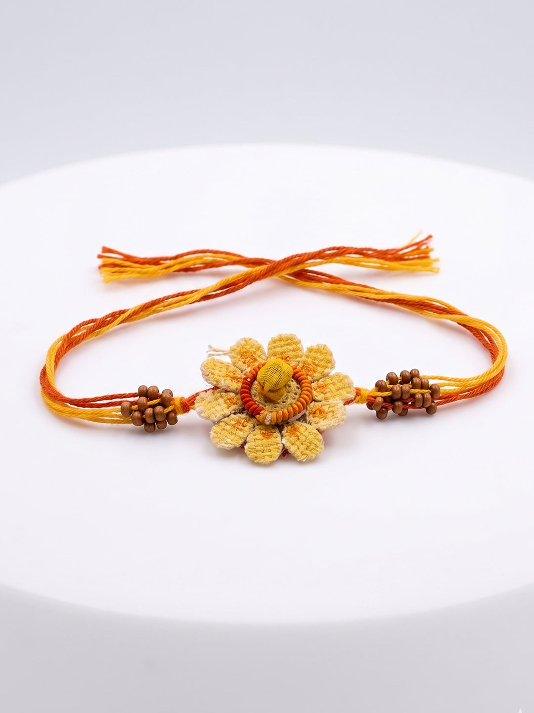NVR Yellow Floral Seed Thread Rakhi with Roli Chawal Chandan Mishri | Grocsy