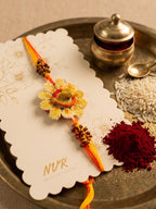 NVR Yellow Floral Seed Thread Rakhi with Roli Chawal Chandan Mishri | Grocsy