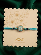 NVR Blue Evil Eye & Artificial Stones Oval Shape Thread Rakhi with Roli Chawal Chandan | Grocsy