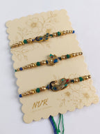 NVR Set of 3 Peacock Design Multicolor Artificial Beads Thread Rakhi With Roli Chawal | Grocsy