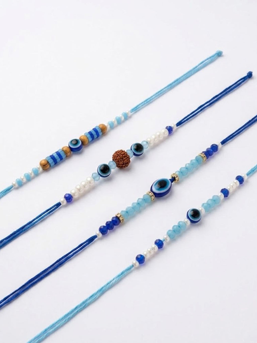 NVR Set of 4 Blue Evil Eye Thread Rakhi with Roli Chawal Chandan Mishri | Grocsy