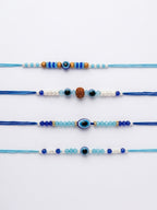 NVR Set of 4 Blue Evil Eye Thread Rakhi with Roli Chawal Chandan Mishri | Grocsy