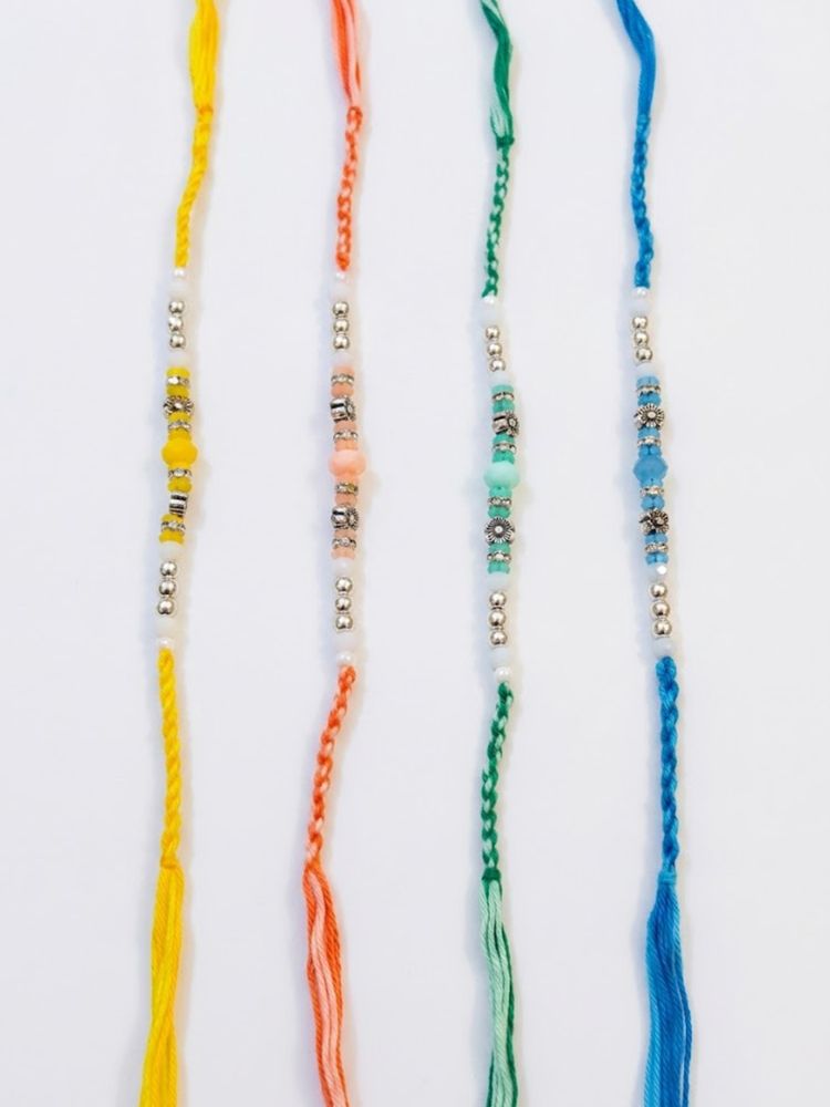 NVR Set of 4 Multicolor Artificial Beads Thread Rakhi with Roli Chawal Chandan Mishri | Grocsy