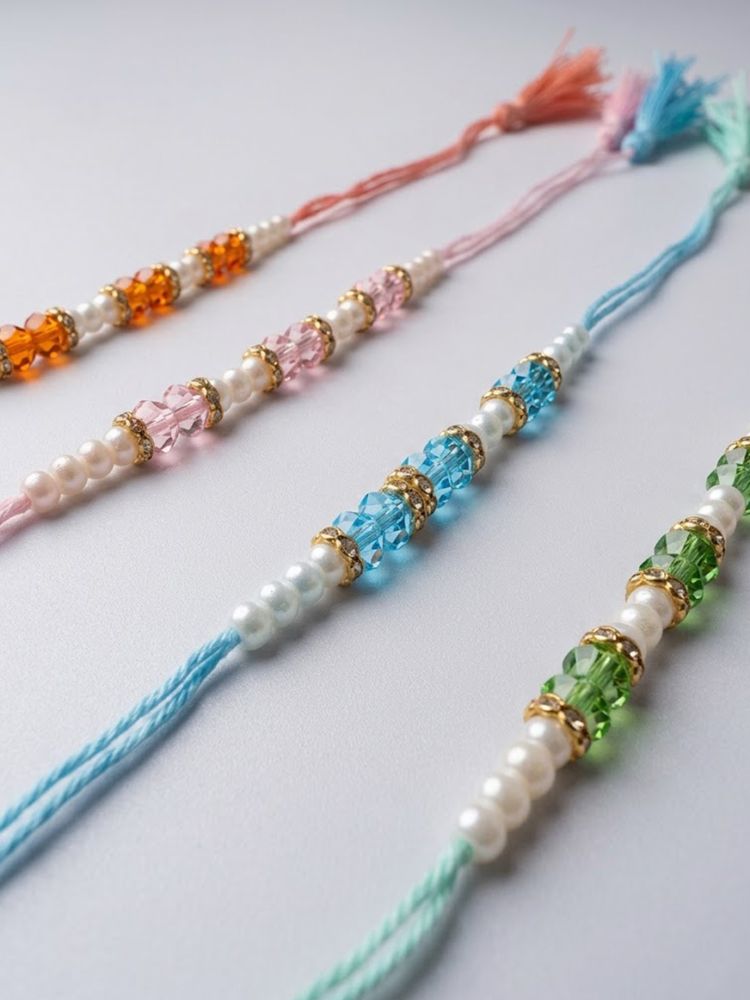 NVR Set of 4 White Pearls & Multicolor Thread Rakhi With Roli Chawal Chandan Mishri | Grocsy