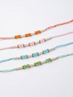 NVR Set of 4 White Pearls & Multicolor Thread Rakhi With Roli Chawal Chandan Mishri | Grocsy