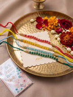 NVR Set of 4 Multicolor Artificial Beads Thread Rakhi with Roli Chawal Chandan Mishri | Grocsy