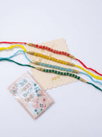 NVR Set of 4 Multicolor Artificial Beads Thread Rakhi with Roli Chawal Chandan Mishri | Grocsy