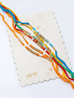 NVR Set of 6 Multi Artificial Beads Thread Rakhi with Roli Chawal Chandan Mishri | Grocsy