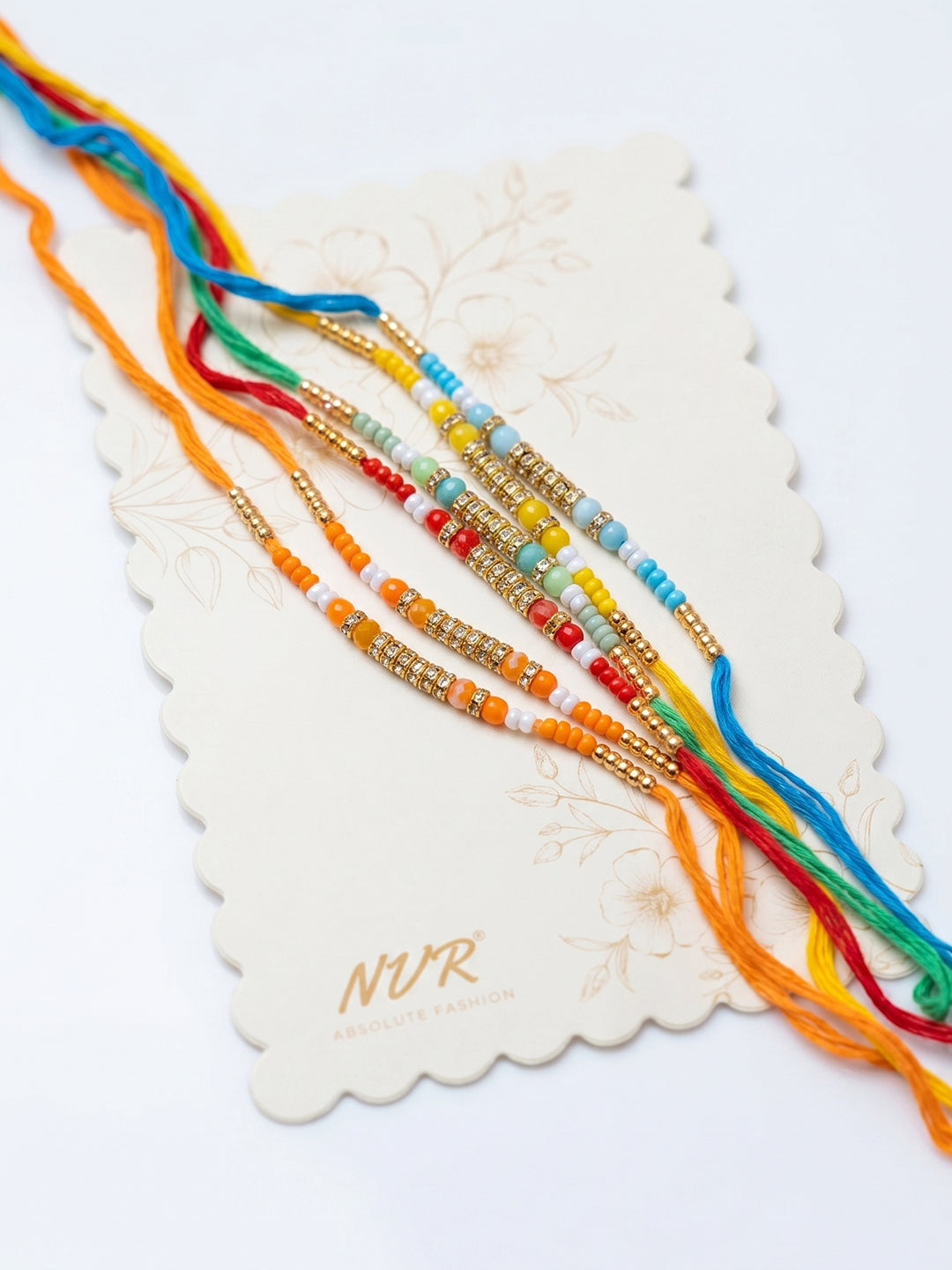 NVR Set of 6 Multi Artificial Beads Thread Rakhi with Roli Chawal Chandan Mishri | Grocsy
