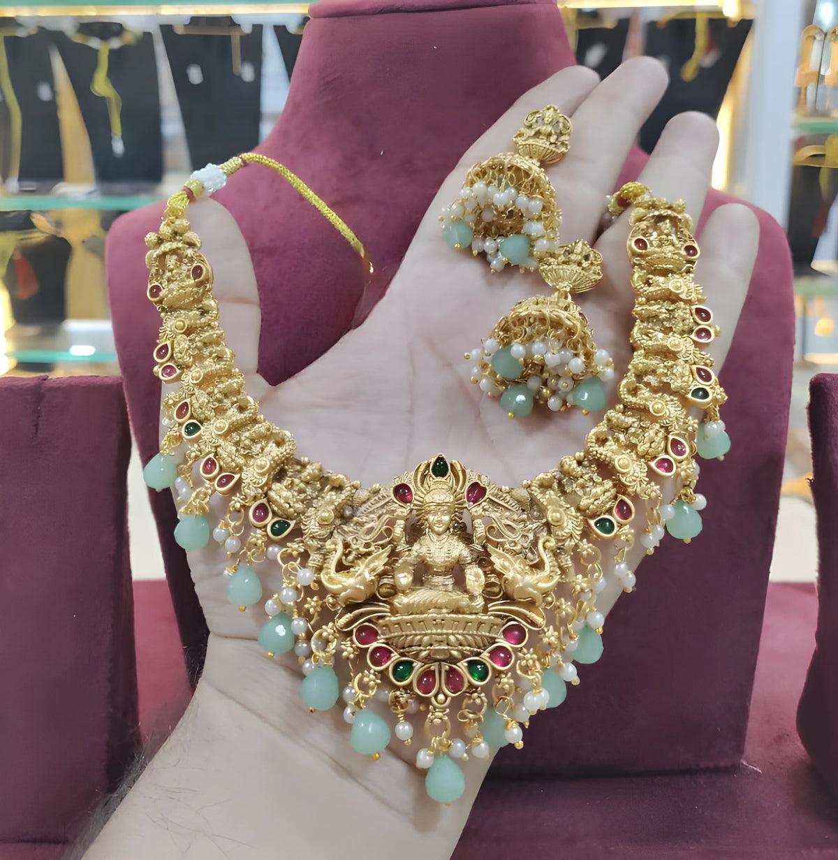 Jewel City Opulent Gold Peacock Lakshmi Temple Necklace Set - Handcrafted Antique Finish Bridal Jewelry with Emerald & Pearl Accent | Grocsy