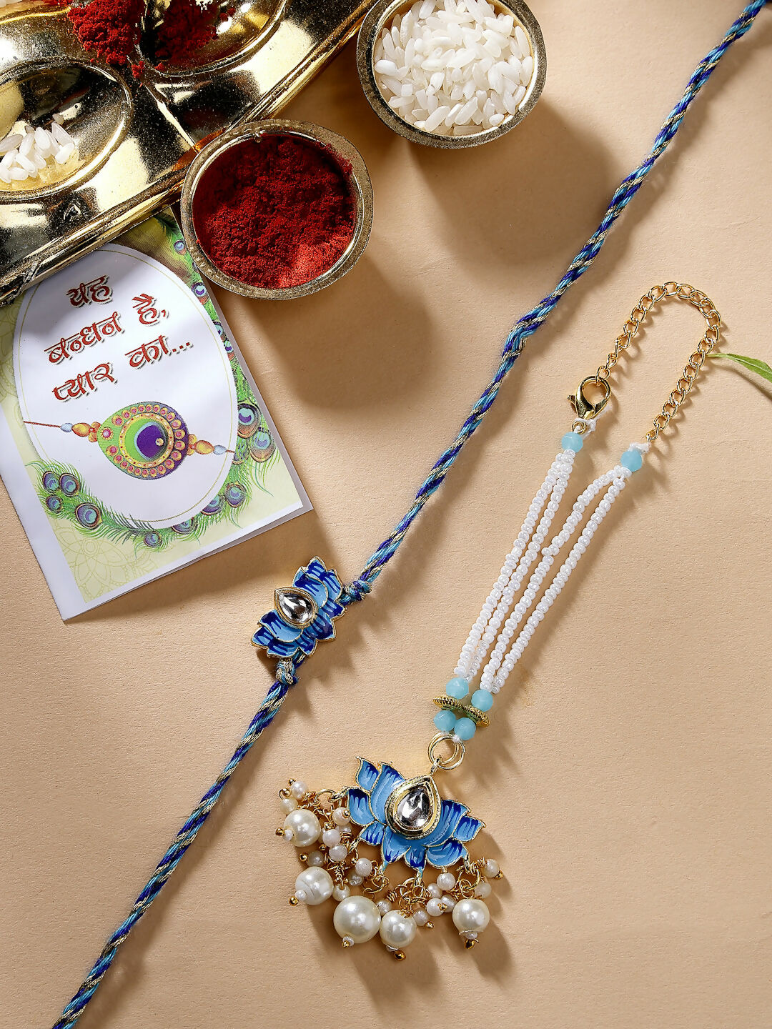 NVR Women & Men Set of 2 Blue Lotus Shape Kundan-Studded & Beaded Handcrafted Wraparound Rakhi Set With Roli Chawal | Grocsy