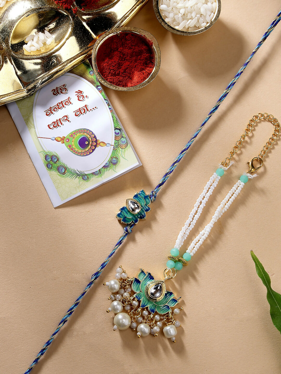 NVR Women & Men Set of 2 Turquoise Blue Lotus Shape Kundan-Studded & Beaded Rakhi Set With Roli Chawal & Chocolate | Grocsy