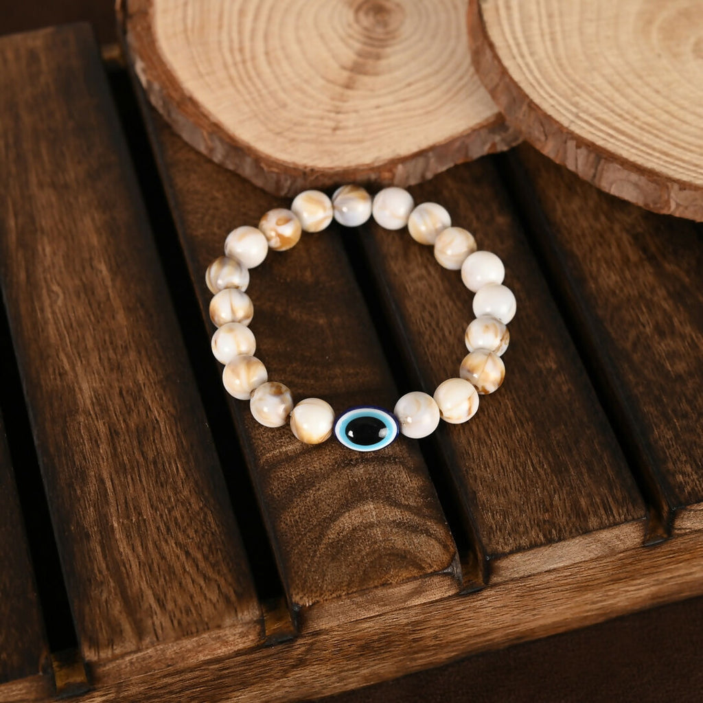 NVR Women & Men Cream-colored Evil Eye Elasticated Rakhi With Roli Chawal | Grocsy